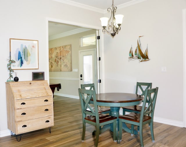 dining area with crown molding, dark wood-type flooring, and an inviting chandelier