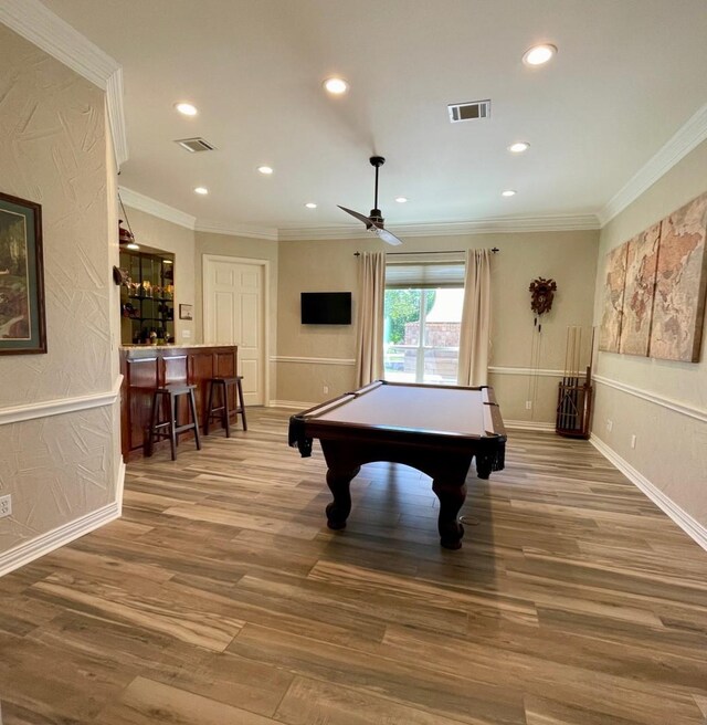 recreation room with ceiling fan, billiards, crown molding, wood-type flooring, and bar