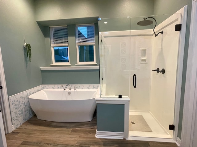 bathroom with hardwood / wood-style flooring and separate shower and tub