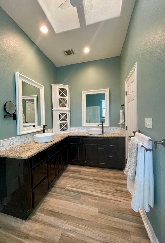 bathroom featuring ceiling fan, hardwood / wood-style floors, and vanity