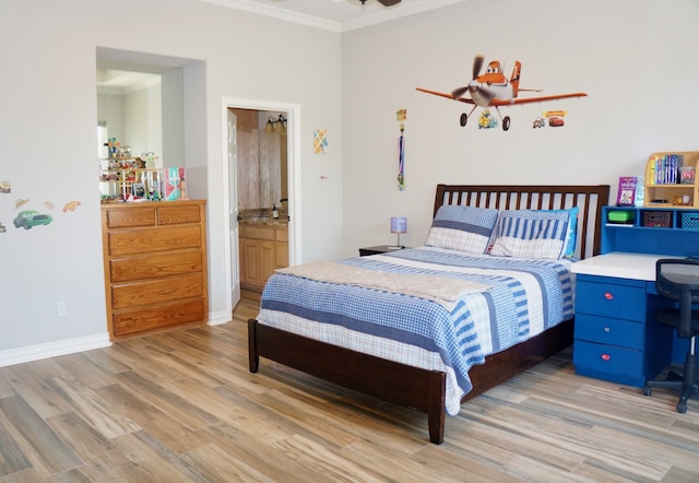 bedroom featuring ensuite bathroom, light wood-type flooring, and crown molding