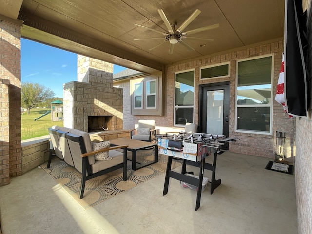 view of patio with an outdoor living space with a fireplace and ceiling fan