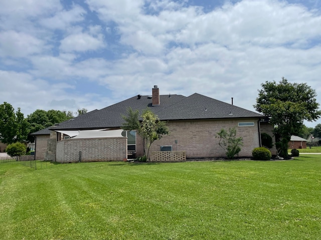 rear view of property with a yard