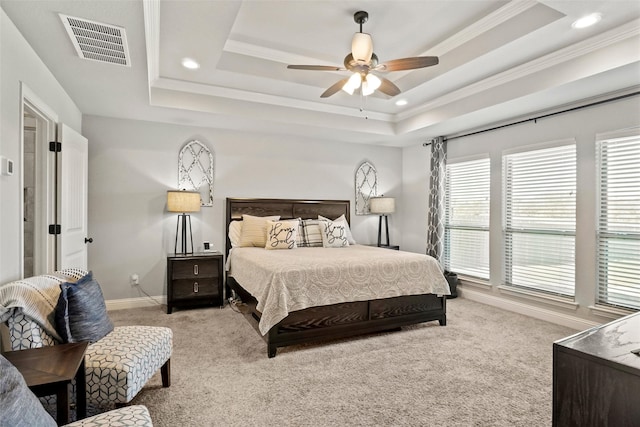 carpeted bedroom featuring ceiling fan, crown molding, and a tray ceiling