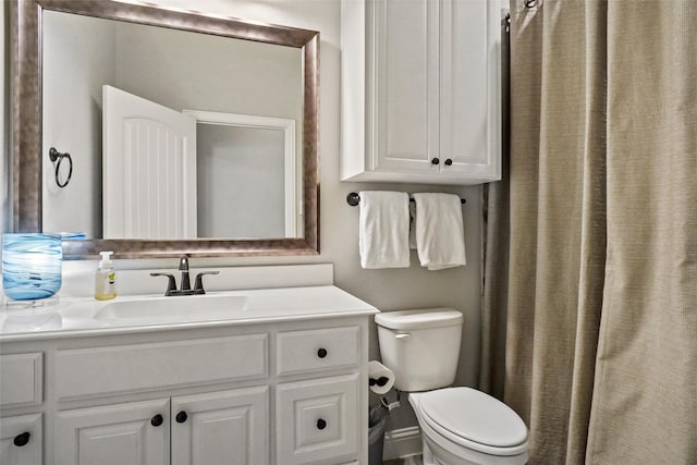 bathroom featuring curtained shower, vanity, and toilet