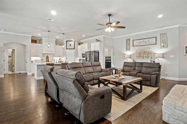 living room with dark hardwood / wood-style floors, ceiling fan, and ornamental molding