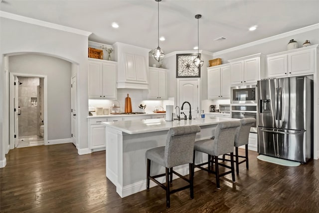 kitchen featuring white cabinetry, a center island with sink, dark hardwood / wood-style floors, and appliances with stainless steel finishes