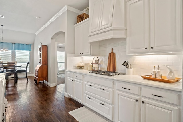 kitchen with premium range hood, white cabinetry, hanging light fixtures, and a healthy amount of sunlight