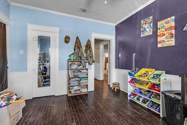 playroom with a textured ceiling, crown molding, and dark wood-type flooring