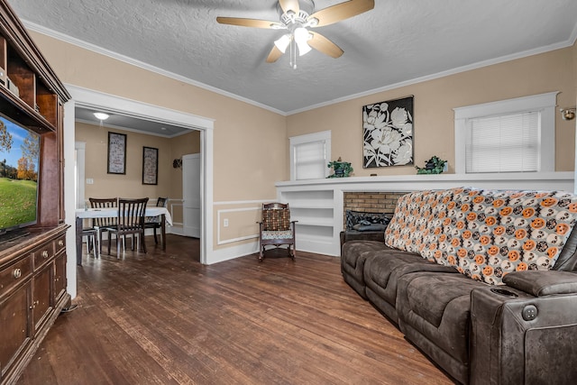 living room with a textured ceiling, crown molding, ceiling fan, and dark wood-type flooring