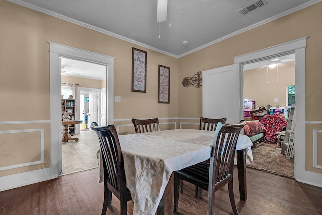 dining room featuring a healthy amount of sunlight, ceiling fan, dark wood-type flooring, and ornamental molding