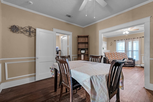 dining space with dark hardwood / wood-style flooring, ceiling fan, and crown molding