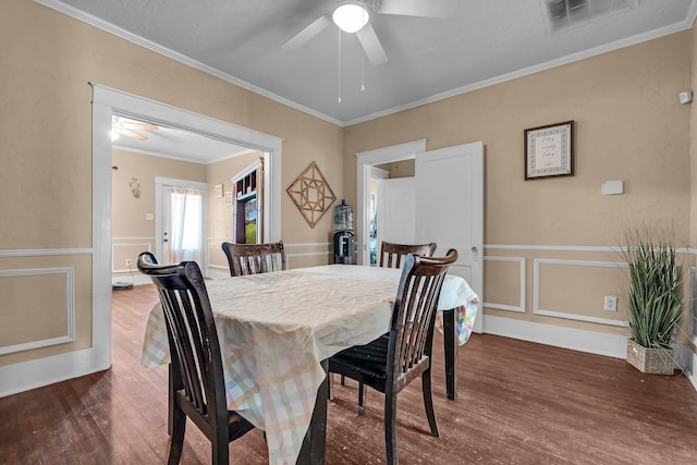 dining room featuring ceiling fan, ornamental molding, and dark wood-type flooring