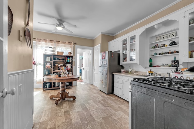 kitchen featuring white cabinetry, ceiling fan, gas range oven, stainless steel fridge, and light hardwood / wood-style floors