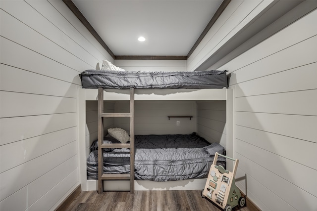 bedroom featuring wooden walls and dark hardwood / wood-style floors