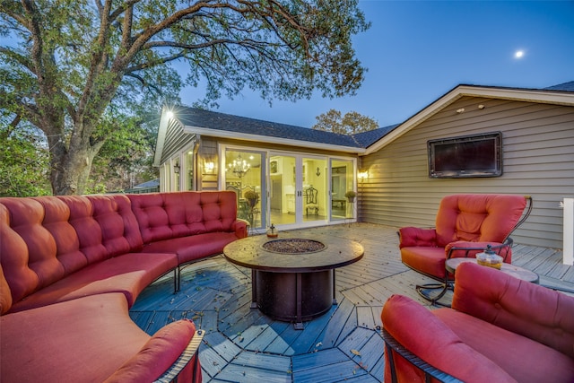 deck at dusk featuring an outdoor living space with a fire pit