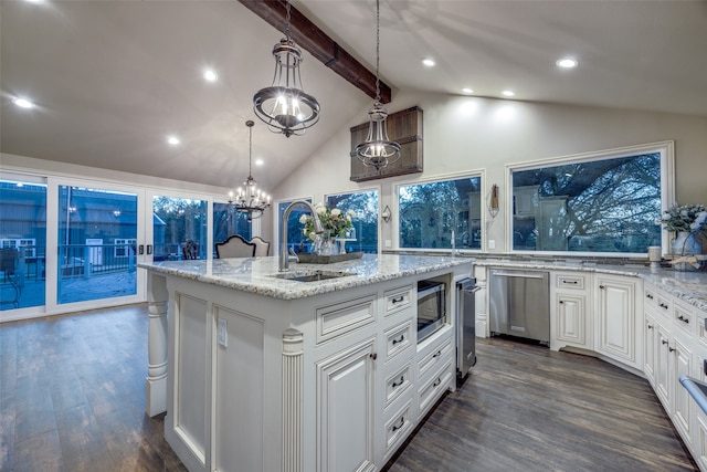 kitchen with sink, pendant lighting, a center island with sink, beamed ceiling, and dark hardwood / wood-style floors