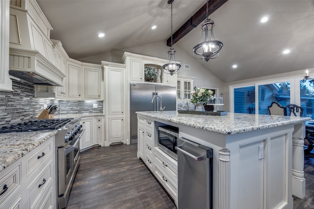 kitchen featuring hanging light fixtures, built in appliances, vaulted ceiling with beams, dark hardwood / wood-style floors, and an island with sink