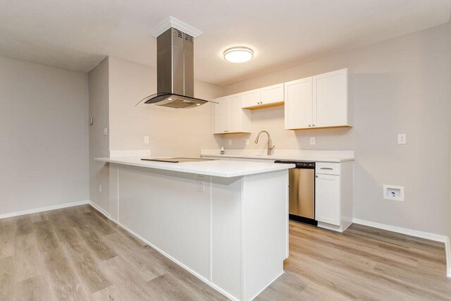 kitchen featuring a peninsula, light wood-style floors, white cabinets, stainless steel dishwasher, and island exhaust hood