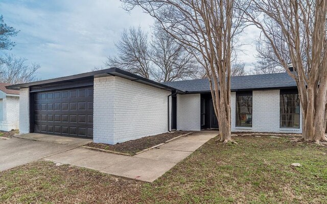 view of front of house featuring a garage and a front lawn