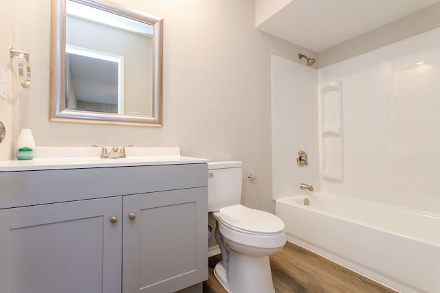 full bathroom with washtub / shower combination, wood-type flooring, vanity, and toilet