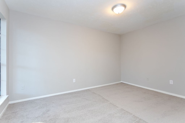 carpeted spare room with baseboards