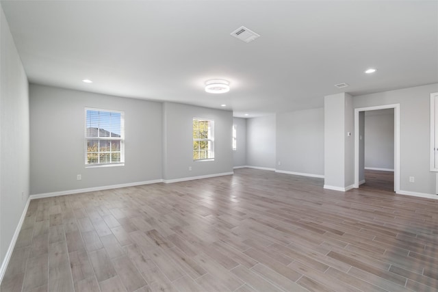 spare room with a wealth of natural light and light wood-type flooring