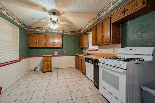 kitchen featuring white appliances, sink, ceiling fan, a textured ceiling, and light tile patterned flooring