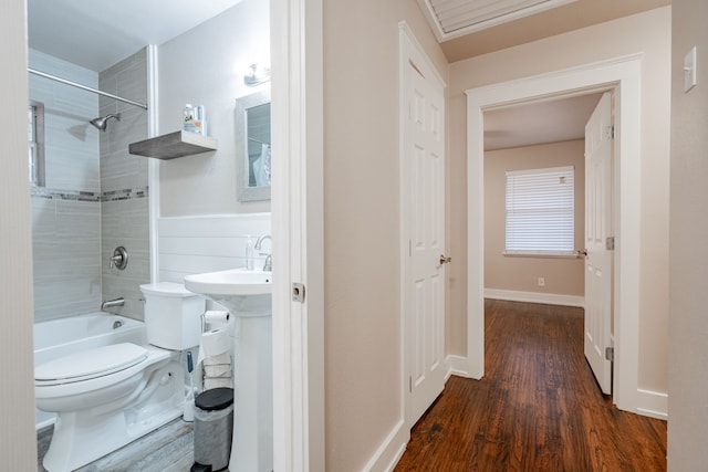 full bathroom featuring sink, hardwood / wood-style floors, tiled shower / bath combo, and toilet