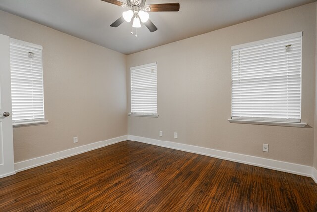 unfurnished room featuring a wealth of natural light, dark hardwood / wood-style floors, and ceiling fan