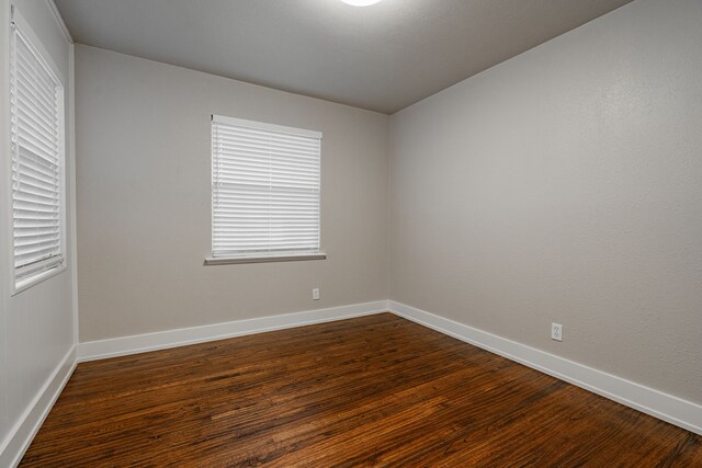 unfurnished room with dark hardwood / wood-style floors