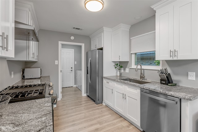 kitchen featuring white cabinets, appliances with stainless steel finishes, and light hardwood / wood-style floors