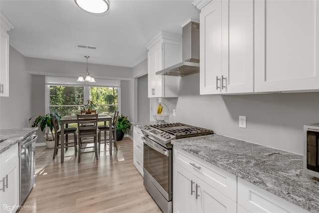 kitchen with white cabinets, wall chimney exhaust hood, stainless steel appliances, and light hardwood / wood-style flooring