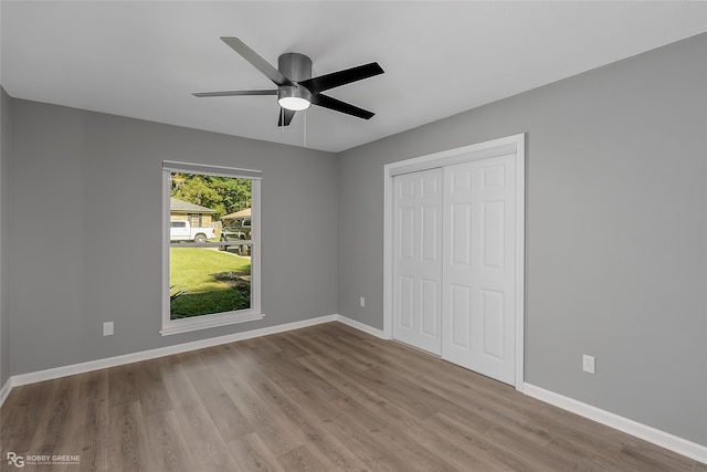 unfurnished bedroom featuring ceiling fan, light hardwood / wood-style floors, and a closet