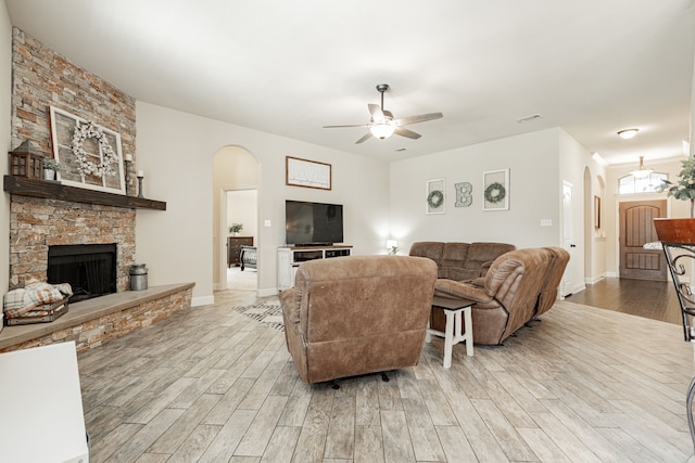 living room with a fireplace, light hardwood / wood-style floors, and ceiling fan