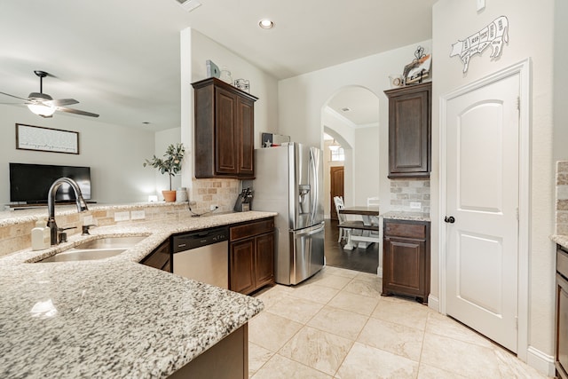 kitchen featuring dark brown cabinets, sink, stainless steel appliances, and tasteful backsplash