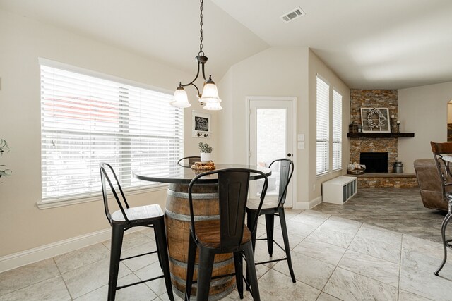 dining area featuring a fireplace, a healthy amount of sunlight, and lofted ceiling