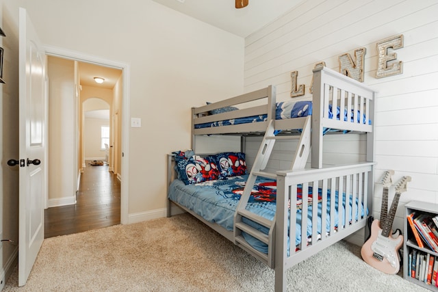 bedroom with wooden walls and hardwood / wood-style flooring