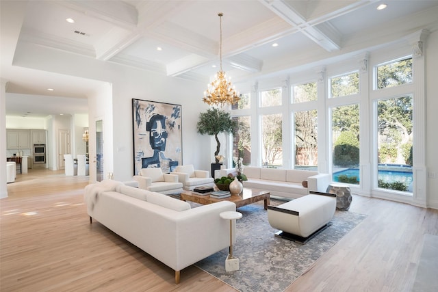 living room with coffered ceiling, a notable chandelier, and beam ceiling