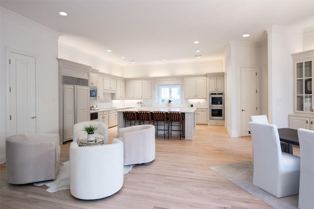 living room featuring ornamental molding and light hardwood / wood-style floors