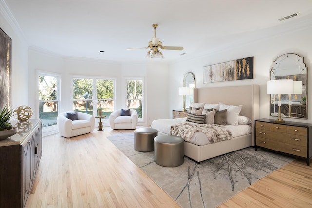 bedroom with multiple windows, ornamental molding, ceiling fan, and light hardwood / wood-style floors