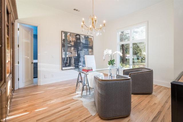 living area featuring crown molding, a chandelier, and light hardwood / wood-style flooring