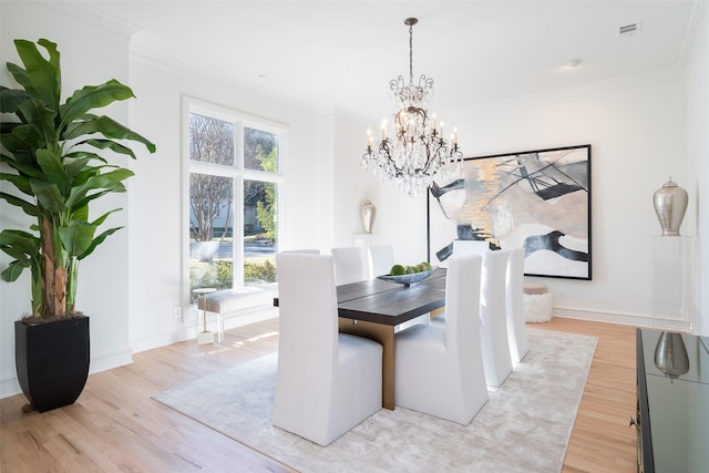 dining room with crown molding, a healthy amount of sunlight, and light wood-type flooring