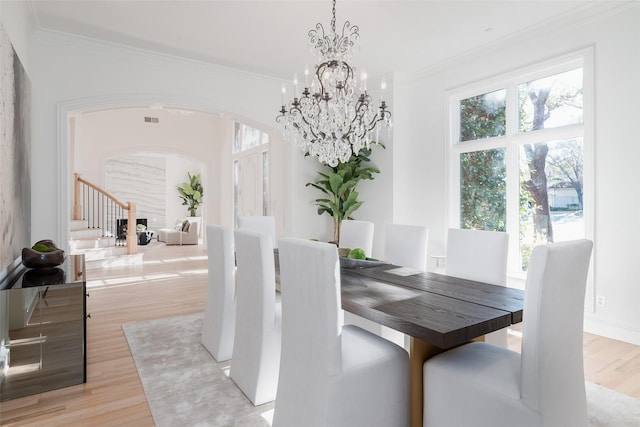 dining room featuring a notable chandelier, light wood-type flooring, and ornamental molding