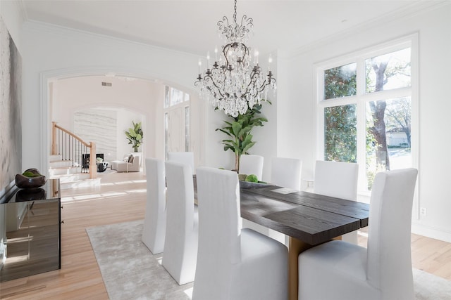 2 Manzano, Dallas, TX 75230 - dining area with arched walkways, ornamental molding, light wood-style floors, and a chandelier