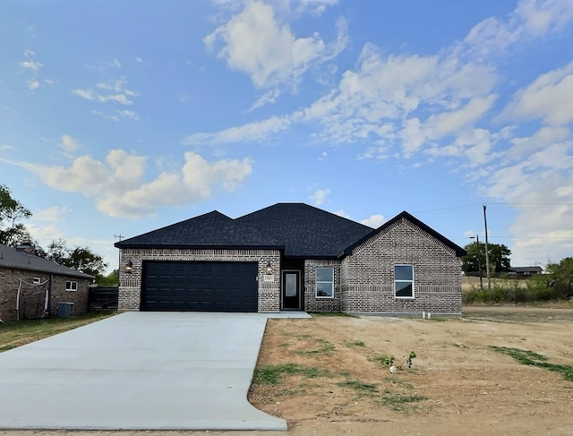 view of front of house with a garage and central air condition unit