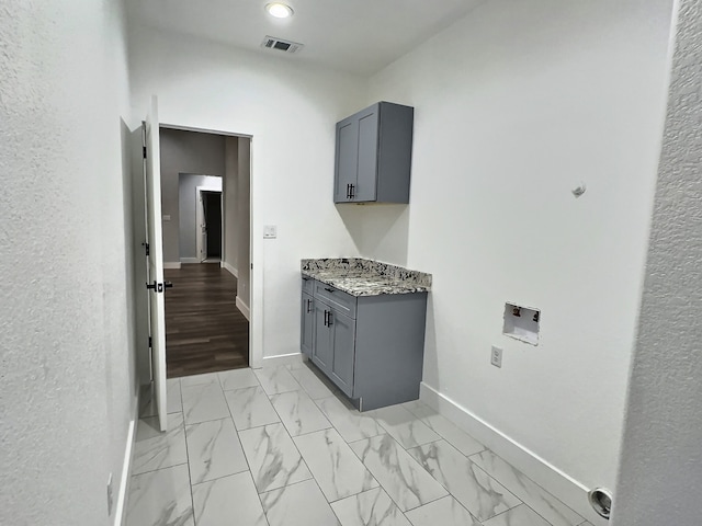 clothes washing area featuring cabinets, light wood-type flooring, and washer hookup