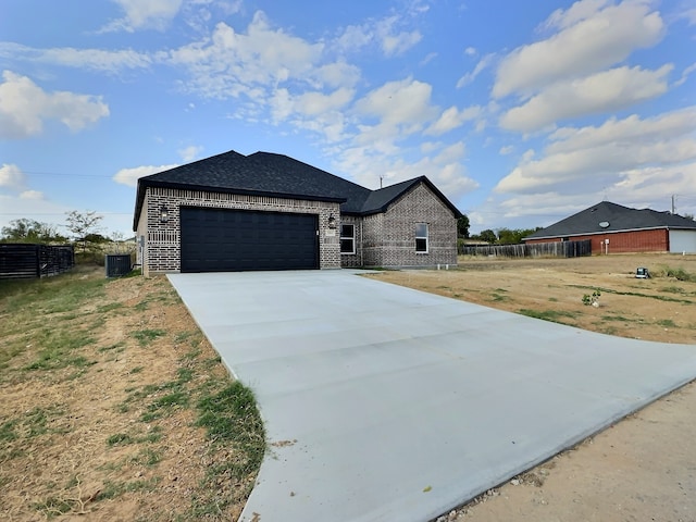 view of front facade featuring central air condition unit, a front lawn, and a garage