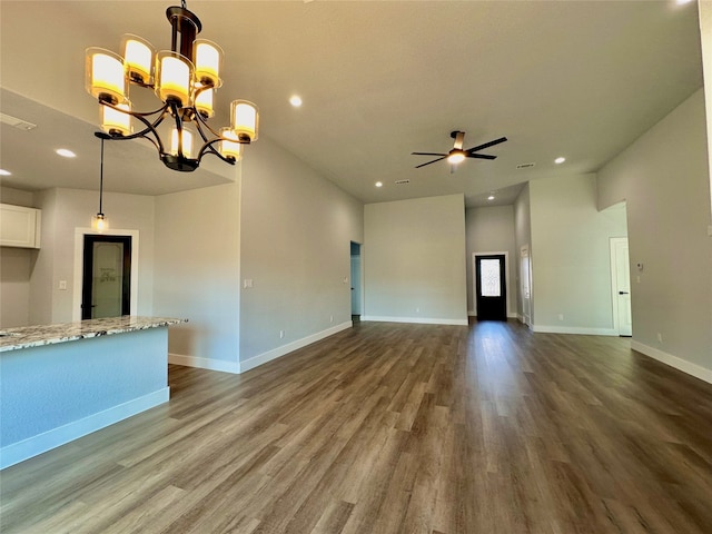 unfurnished living room with dark hardwood / wood-style flooring and ceiling fan with notable chandelier