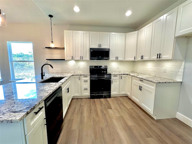 kitchen with black appliances, sink, white cabinets, and hanging light fixtures